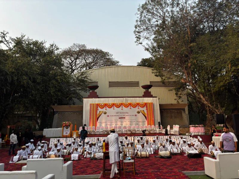 Outdoor open-day anniversary celebration with traditional musicians and marigold stage décor