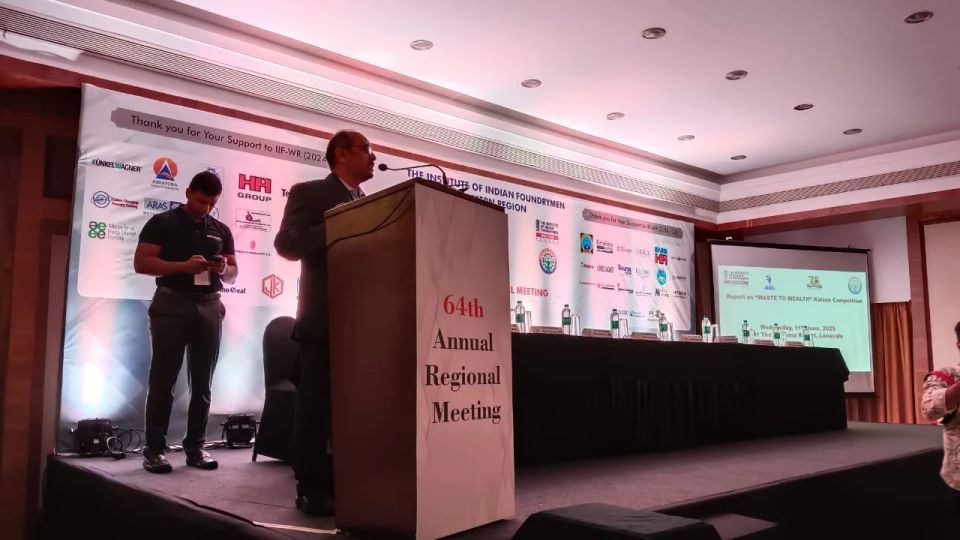 Speaker at a branded podium with sponsor backdrop during a formal industry conference