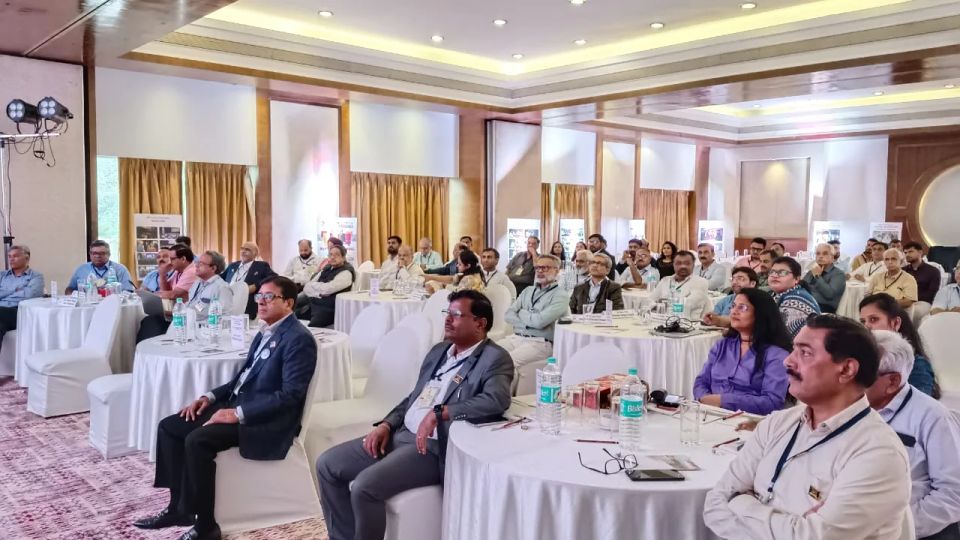 Professionals seated at round banquet tables during a formal industry conference